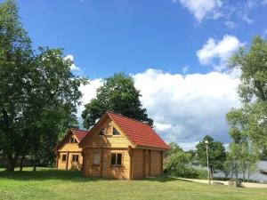 Neptun في Międzychód: منزل خشبي صغير بسقف احمر