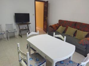 a living room with a white table and a couch at Apartamento Mar de Fóra in Finisterre