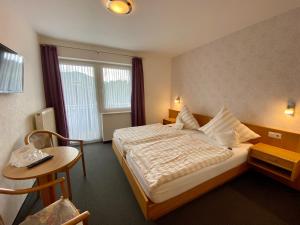 a hotel room with a large bed and a table at TOP FeWo mit SommerCard in Winterberg