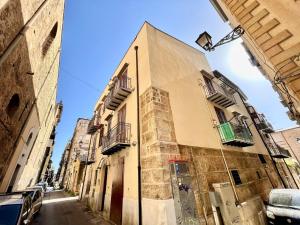 - un bâtiment avec balcon sur le côté d'une rue dans l'établissement PIKKI' AL DUOMO, à Palerme
