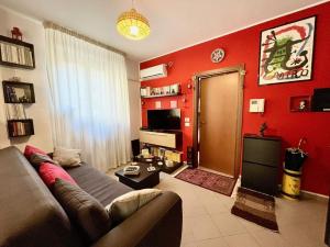 un soggiorno con divano e parete rossa di PIKKI' AL DUOMO a Palermo