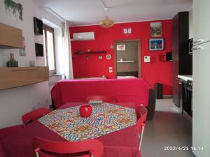 - un salon avec des murs rouges, une table et des chaises dans l'établissement PIKKI' AL DUOMO, à Palerme