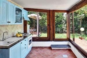 a kitchen with blue cabinets and a large window at Chalet Claudia in Sant'Agnello