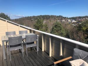 a balcony with a table and chairs on a deck at Sentralt rekkehus med solrik veranda! in Arendal