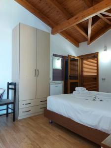a bedroom with a large white bed and a chair at Vila Green Relax in Vlorë