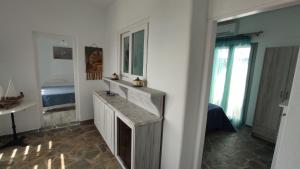 łazienka z umywalką oraz pokój z łóżkiem w obiekcie Anemomylos Houses w Koufonisii +37 zdjęć
