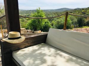 a straw hat sitting on a bench with a view at Villa Monte da Alfarrobeira in Estói