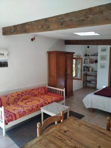 ein Wohnzimmer mit einem Bett und einem Tisch in der Unterkunft Les Granges de la hulotte, les Mésanges in Lies