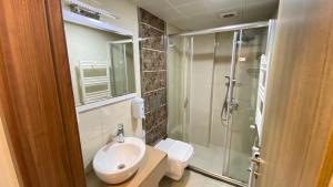 a bathroom with a sink and a glass shower at Ayder Resort Hotel in Ayder Yaylasi