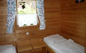 a small room with a bed and a window at Ferienhaus Nr 28, Typ A, Feriendorf Jägerpark, Bayerischer Wald in Viechtach