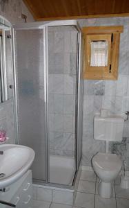 y baño con ducha, aseo y lavamanos. en Ferienhaus Nr 25, Typ A, Feriendorf Jägerpark, Bayerischer Wald, en Viechtach
