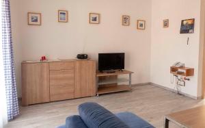 a living room with a couch and a television on a cabinet at Ferienhaus Nr 91, Kategorie Komfort, Feriendorf Hochbergle, Allgäu in Karlsebene