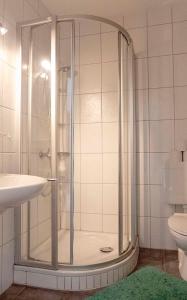 a bathroom with a shower and a sink at Ferienhaus Nr 91, Kategorie Komfort, Feriendorf Hochbergle, Allgäu in Karlsebene