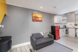 a living room with a chair and a kitchen at Luxury Living - Lovely 1 Bedroom Apartment in Stockton-on-Tees