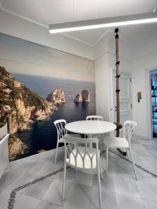 a white dining room with a view of the ocean at Domus Le Botteghe in Capri