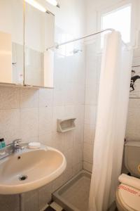 ein Bad mit einem Waschbecken, einem WC und einer Dusche in der Unterkunft Fedra Hotel in Chrisi Ammoudia