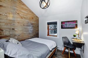- une chambre avec un lit et un mur en bois dans l'établissement Chalets Alpins- 08 Chemin Alpin, à Stoneham