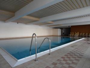 a swimming pool in a hotel with chairs and tables at Ferienwohnung Nr 26, Appartementhaus-Hintermoos, Maria-Alm, Österreich in Bachwinkl