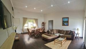 uma sala de estar com um sofá e uma mesa em Cosy Beach House em Port Shepstone