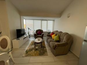 a living room with a couch and a tv at Shkodra Duplex Apartment in Shkodër