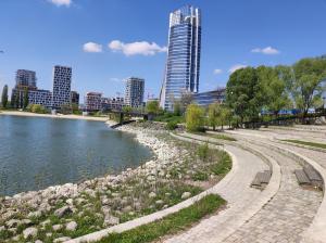 a park with benches next to a river and a city at Riverside apartment by the Danube in Budapest