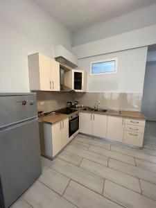 cocina con armarios blancos y suelo de baldosa en Shkodra Duplex Apartment, en Shkodër