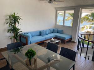 a living room with a blue couch and a table at Penthouse Ave Paraiso en Manzanillo 505 Apt 16b in Manzanillo