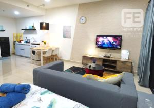 ein Wohnzimmer mit einem Sofa und einem TV in der Unterkunft Netflix WiFi Cozy Homestay Trefoil Setia Alam Shah Alam 沙亚南舒适温馨日租民宿 in Setia Alam