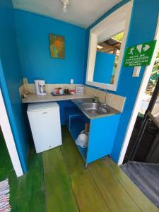 een keuken met een wastafel en een blauwe muur bij Donde Familia Manito in Paquera