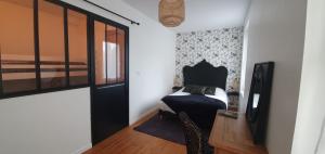 ein Schlafzimmer mit einem Bett und einem Schreibtisch mit einem Fernseher in der Unterkunft "Ô Tour's Angels" RABELAIS in Tours