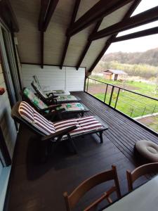 eine Terrasse mit Stühlen, einem Tisch und einem Fenster in der Unterkunft Villa Opir in Skole