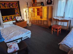 a bedroom with two beds and a dresser and a chair at Etno kuća Parče neba in Užice