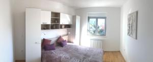 ein Schlafzimmer mit einem Bett mit lila Kissen in der Unterkunft Apartment Angela with private garage slot in Pula