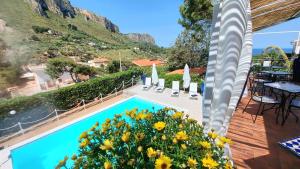 a view of a swimming pool with flowers on a deck at VFH Villa Flavia Eco B&B - 50 metri dal mare in Santa Flavia