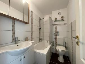La salle de bains blanche est pourvue d'un lavabo et de toilettes. dans l'établissement Ferienappartment am Kurpark. 100m zum Strand., à Ulstrupfeld