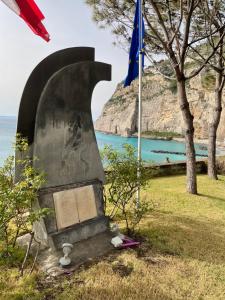 un monumento frente al océano con una bandera en Appartamento Meta di Sorrento Le Sirene, en Meta