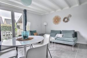 ein Wohnzimmer mit einem Tisch und einem Sofa in der Unterkunft L'agapanthe in Saint-Gildas-de-Rhuys