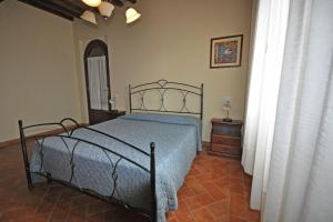 PonteginoriにあるAgriturismo San Maurizio Alto by ToscanaTourのベッドルーム1室(青い掛け布団付きのベッド1台付)