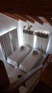 2 camas en una habitación con cortinas blancas en La Liebre en Federación