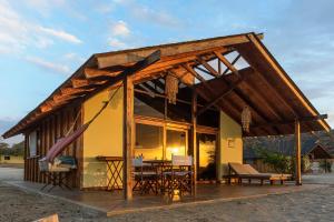a pavilion with a table and chairs in front of a building at Wallac Bungalows Canoas de Punta Sal in Canoas de Punta Sal