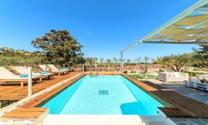 a large swimming pool with a wooden deck at Cretan Lodge Heated Pool in Agios Nikolaos