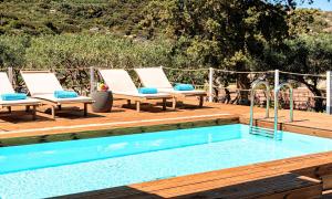 een zwembad met ligstoelen op een houten terras bij Cretan Lodge Heated Pool in Agios Nikolaos