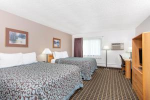 a hotel room with two beds and a television at Days Inn by Wyndham Fond du Lac in Fond du Lac