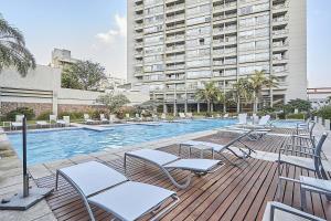 a swimming pool with lounge chairs and a large building at Quartier San Telmo Luxury Pool Gym & Spa, piscina climatizada in Buenos Aires
