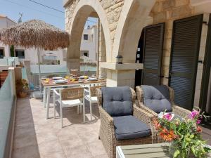 an outdoor patio with chairs and a table and a tableablish at Villa Constancia in Stalos