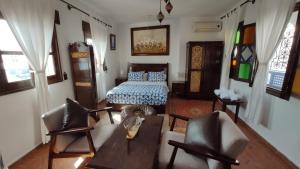 a living room with a bed and a table and chairs at Casa Bellavista Chaouen in Chefchaouene