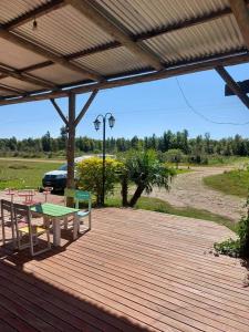 una terraza de madera con mesa y sillas. en La Liebre en Federación