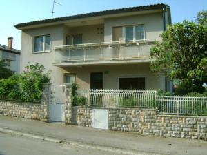 a house with a stone wall and a fence at Apartment for Holidays in Pula in Pula