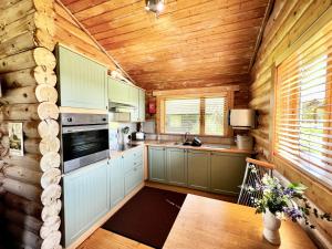 a kitchen in a log cabin with wooden walls at Lindley Log Cabin in Lincoln