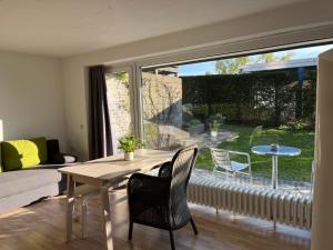 a living room with a table and chairs and a large window at Ferienwohnung Am Sultmer mit Terrasse und Garten in Northeim